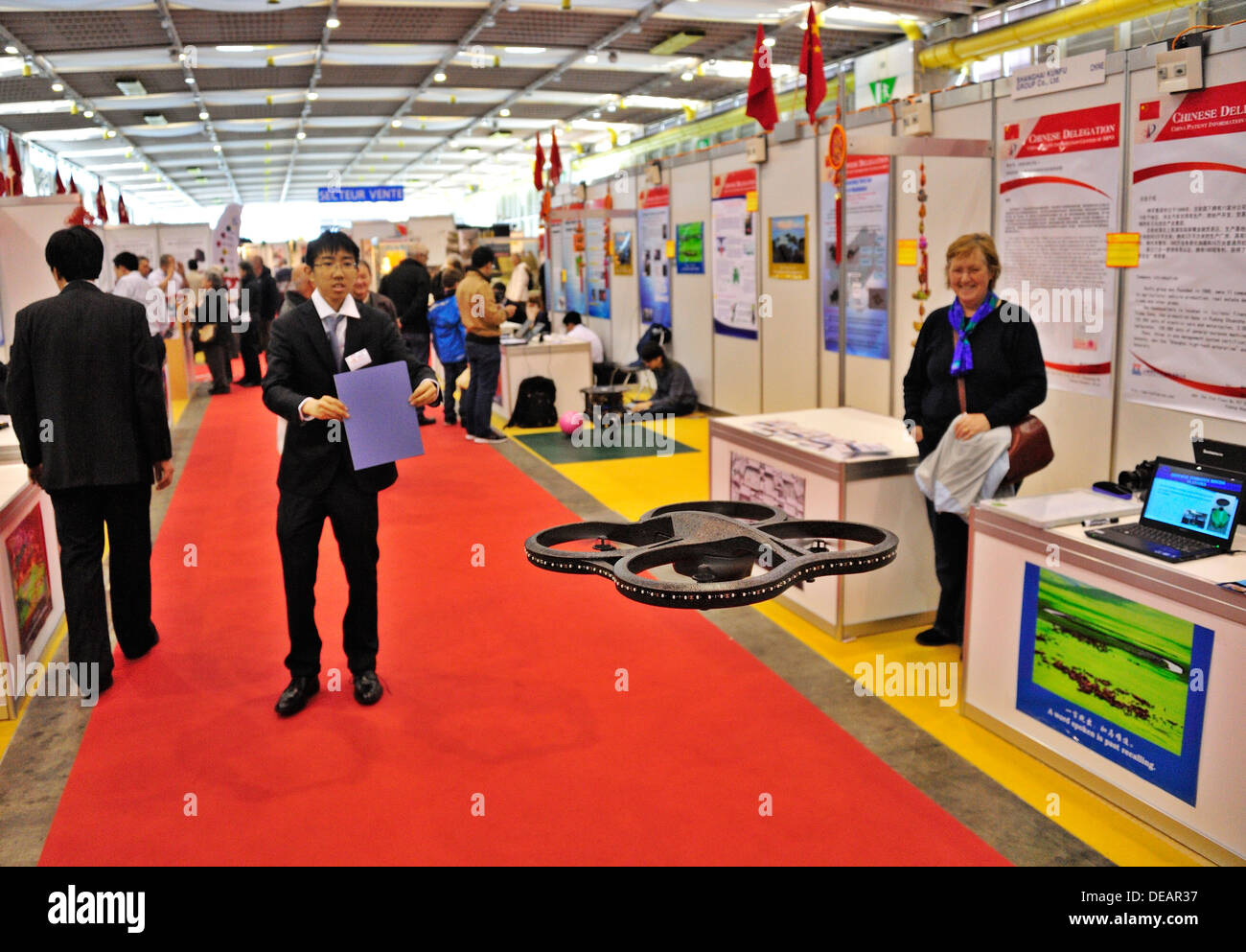 Ein chinesische Erfinder zeigt eine Drohne am Genfer Erfindermesse 2013, während ein Zuschauer blickt auf Stockfoto