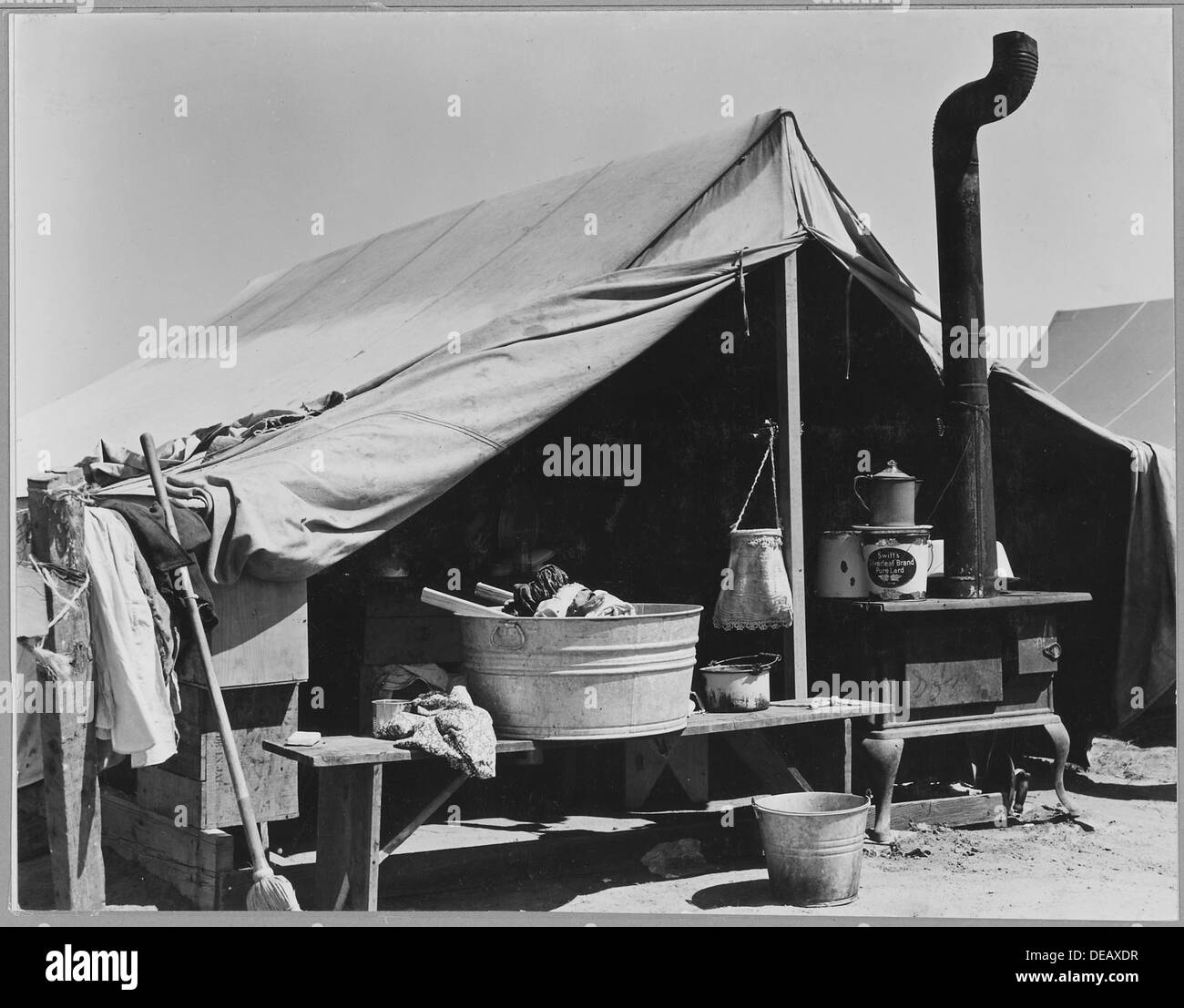 Dieses Bild zeigt Haushaltsgeräte einer Familie von Oklahoma, die entlang einer Autobahn im Kern County, Kalifornien, ausgestellt sind. Die Themen stellen die Herausforderungen dar, denen Migrantenfamilien während der Großen Depression gegenüberstanden. Stockfoto