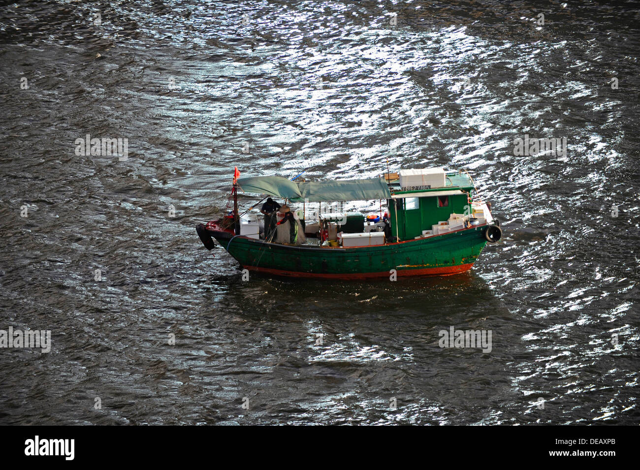 Kleine grüne Fischerboot bei der Arbeit im Hafen von Hong Kong Stockfoto