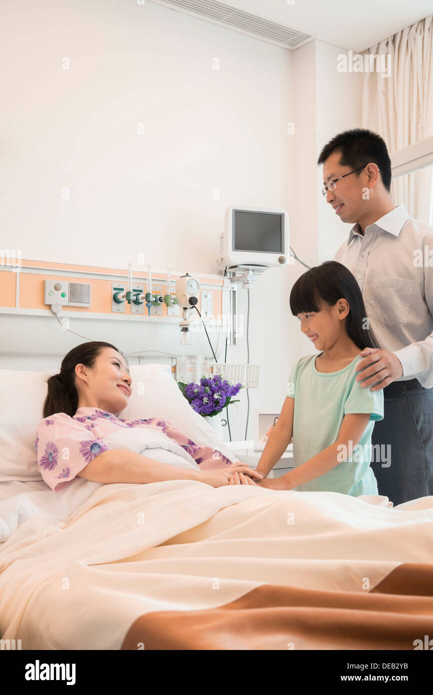 Familie besuchen die Mutter im Krankenhaus, Hand in Hand Stockfoto