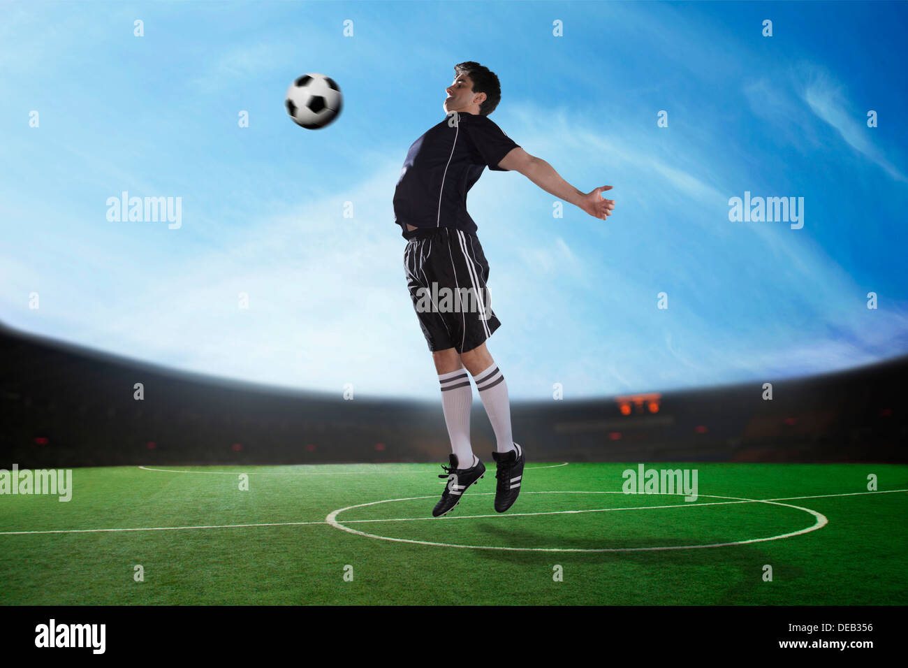 Fußball-Spieler den Ball mit der Brust im Stadion, Tageszeit Stockfoto