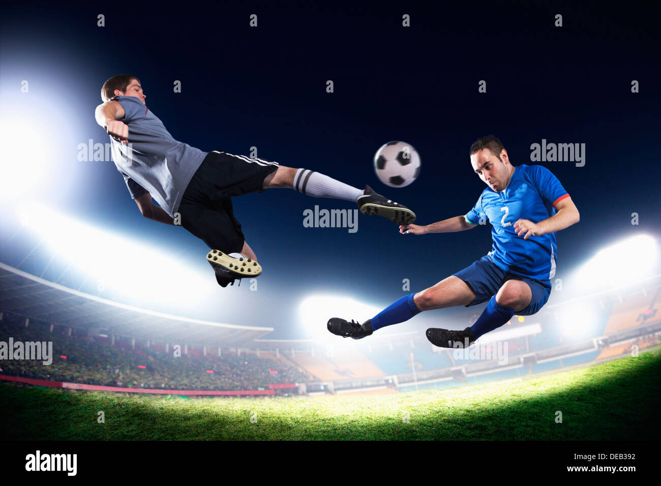Zwei Fußball-Spieler in der Luft treten die Fußball, Stadion Lichter in der Nacht im Hintergrund Stockfoto