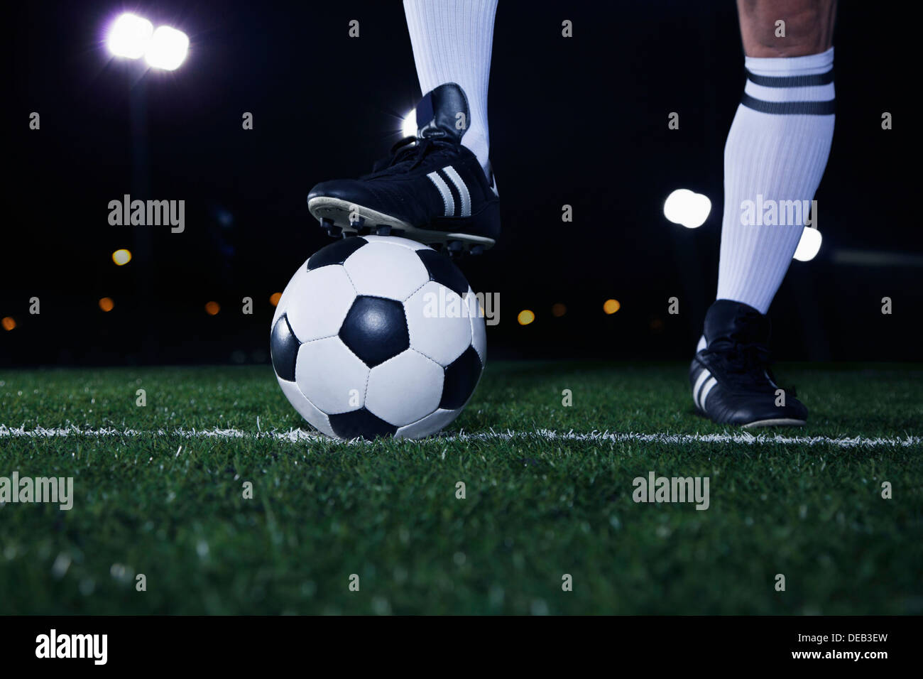 Nahaufnahme eines Füßen auf Fußball Ball auf der Linie nachts im Stadion Stockfoto