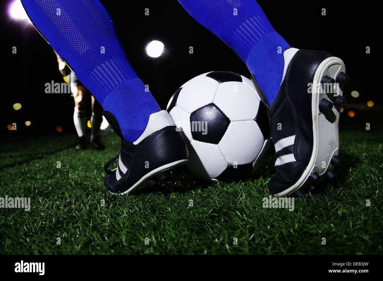Nahaufnahme eines Füßen treten die Fußball, nachts im Stadion Stockfoto