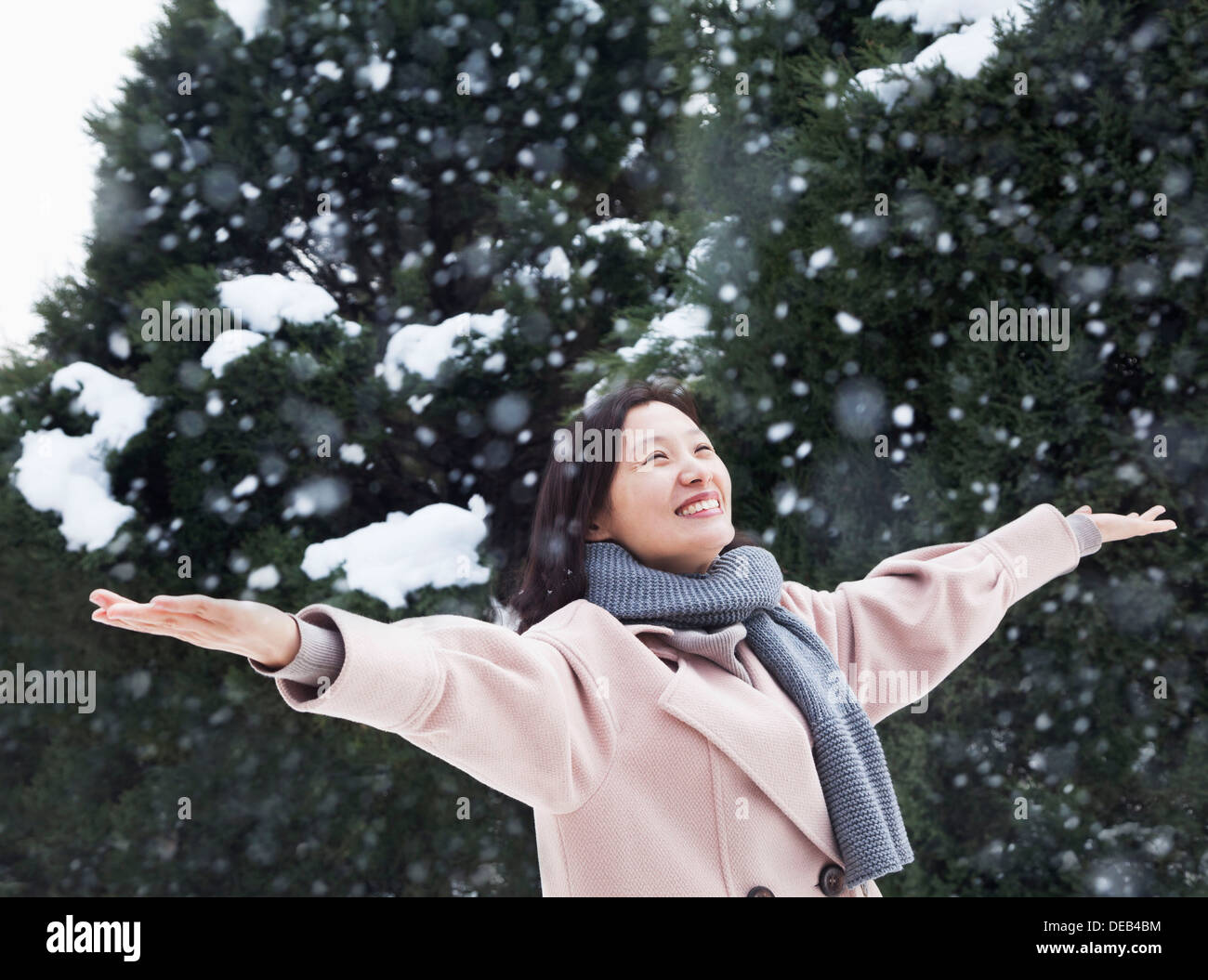 Frau mit ausgestreckten Armen Gefühl im Schnee Stockfoto