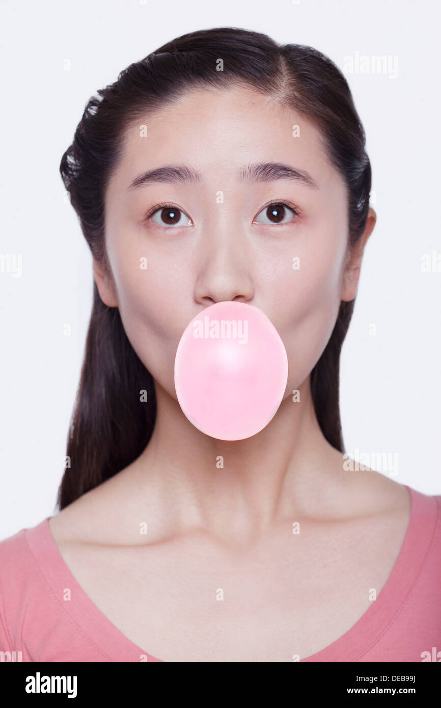 Junge verspielte Frau eine Seifenblase aus Kaugummi, Studio gedreht Stockfoto
