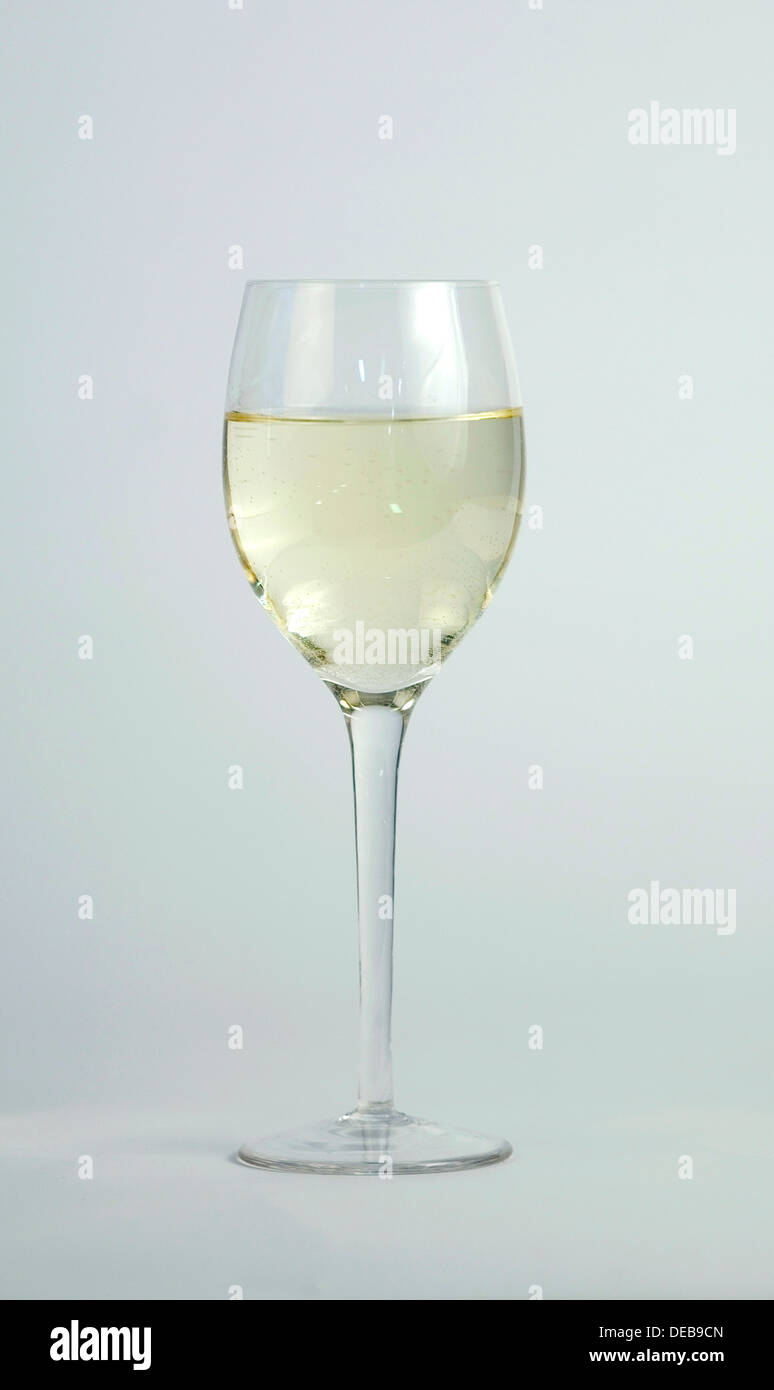 Ein Glas Weißwein auf einem grauen Hintergrund. Stockfoto