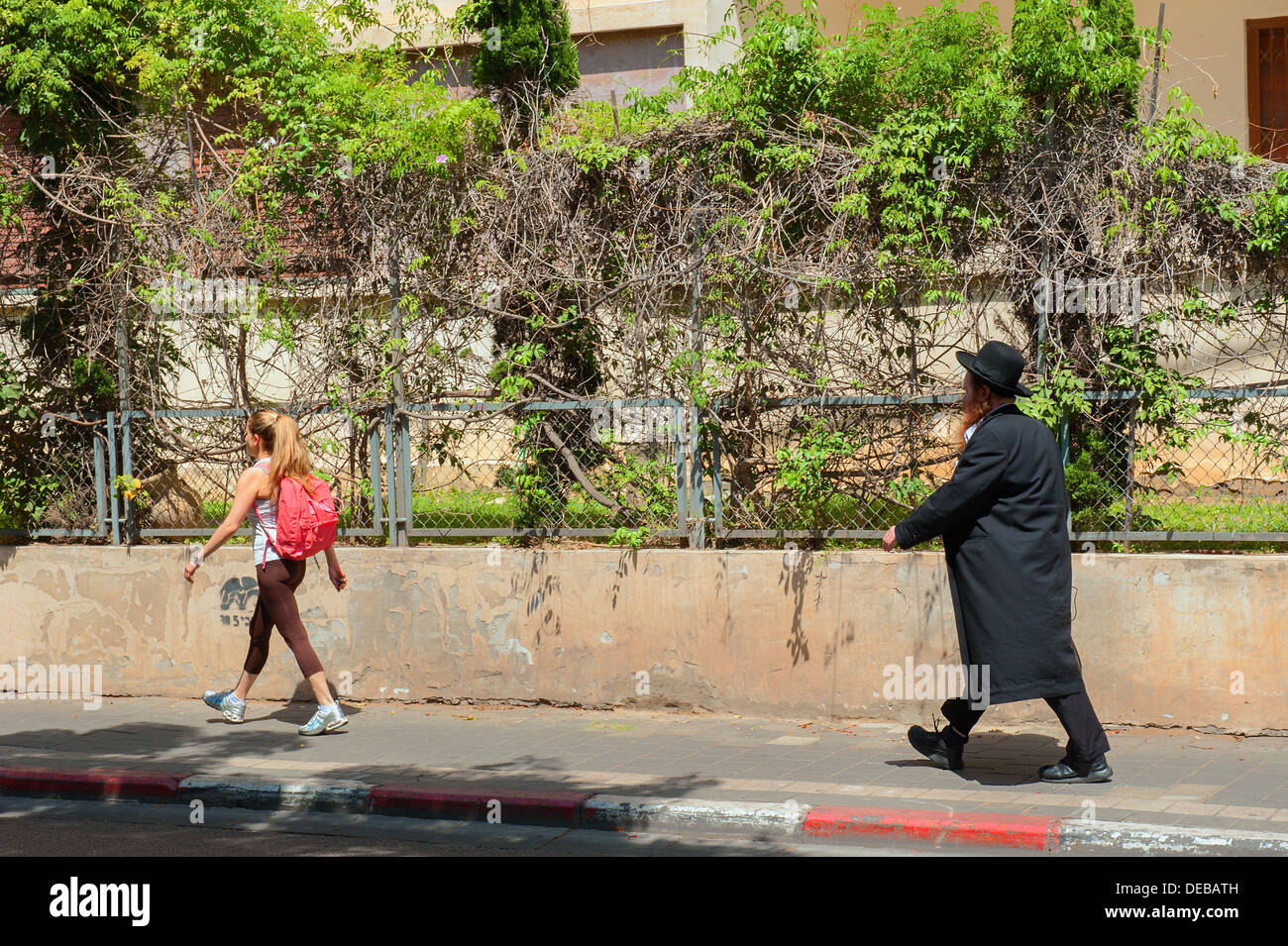 Ein orthodoxer Jude und eine weltliche Frau zu Fuß in Rothschild Boulevard, Tel Aviv, Israel Stockfoto