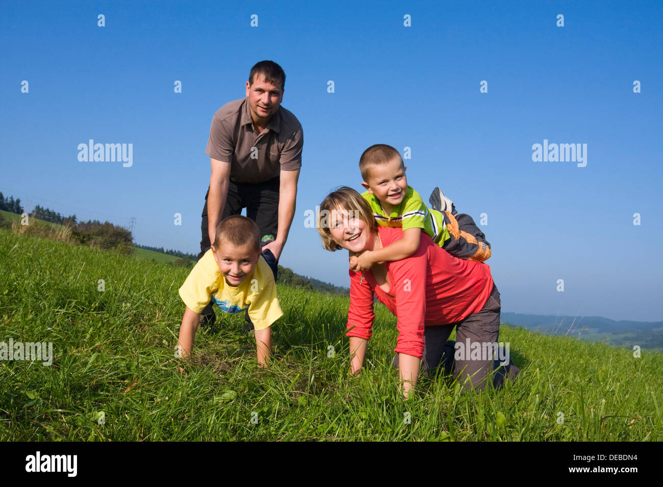 Familie, Vater, 36 Jahre, Mutter, 30 Jahre, Kinder, 6 und 4 Jahren, auf einer Wiese spielen Stockfoto