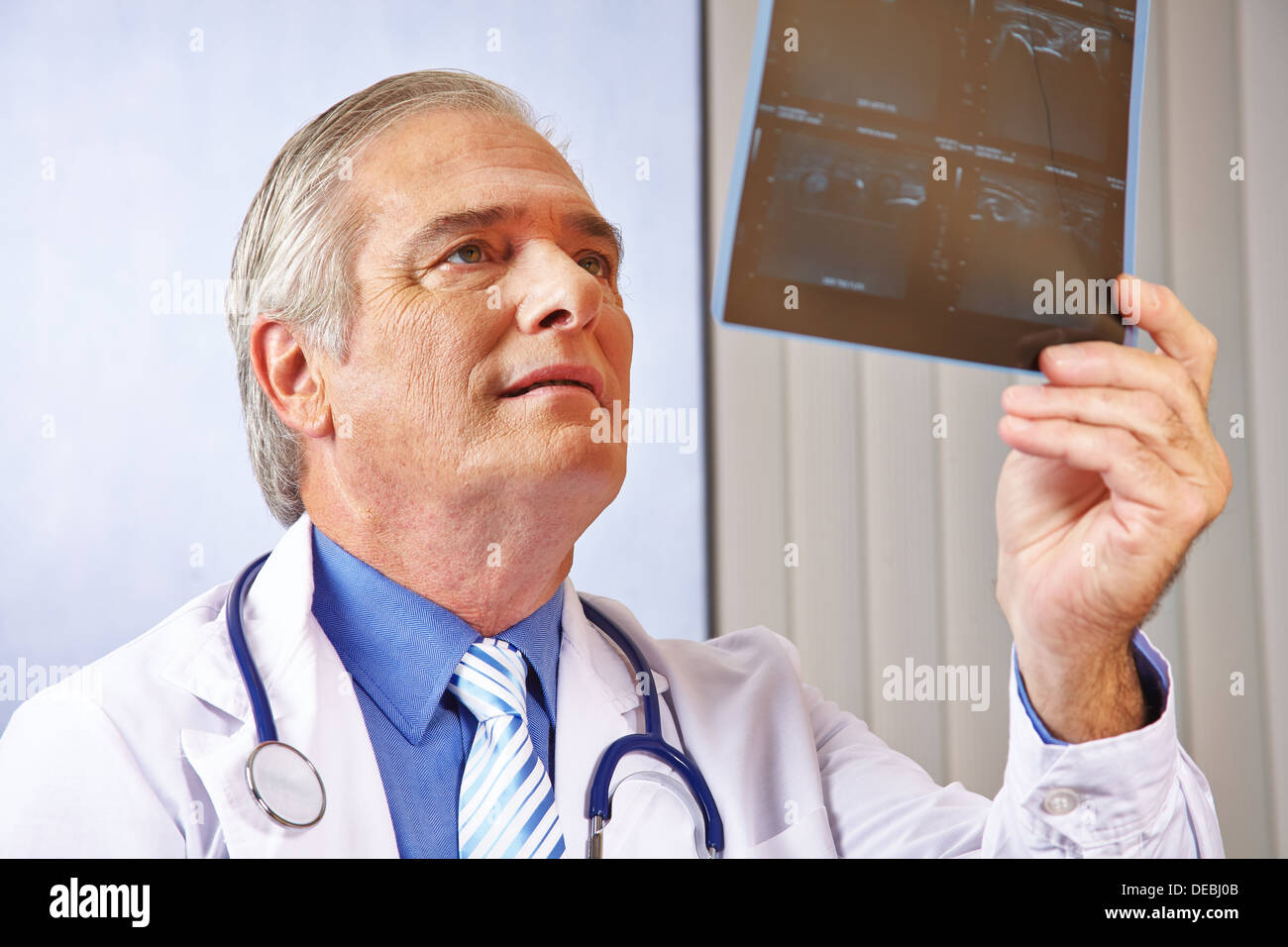 Arzt mit Blick auf Röntgen-Bild in seinem Krankenhaus-Büro Stockfoto