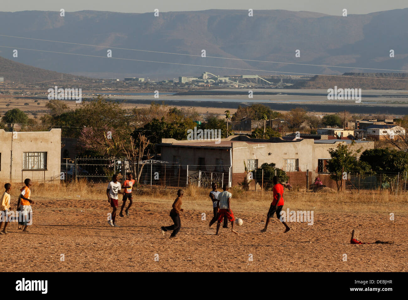 Fußball in Sekuruwe Dorf mit Potgietersrus Platinum Mine im Hintergrund. Limpopo, Südafrika, Stockfoto