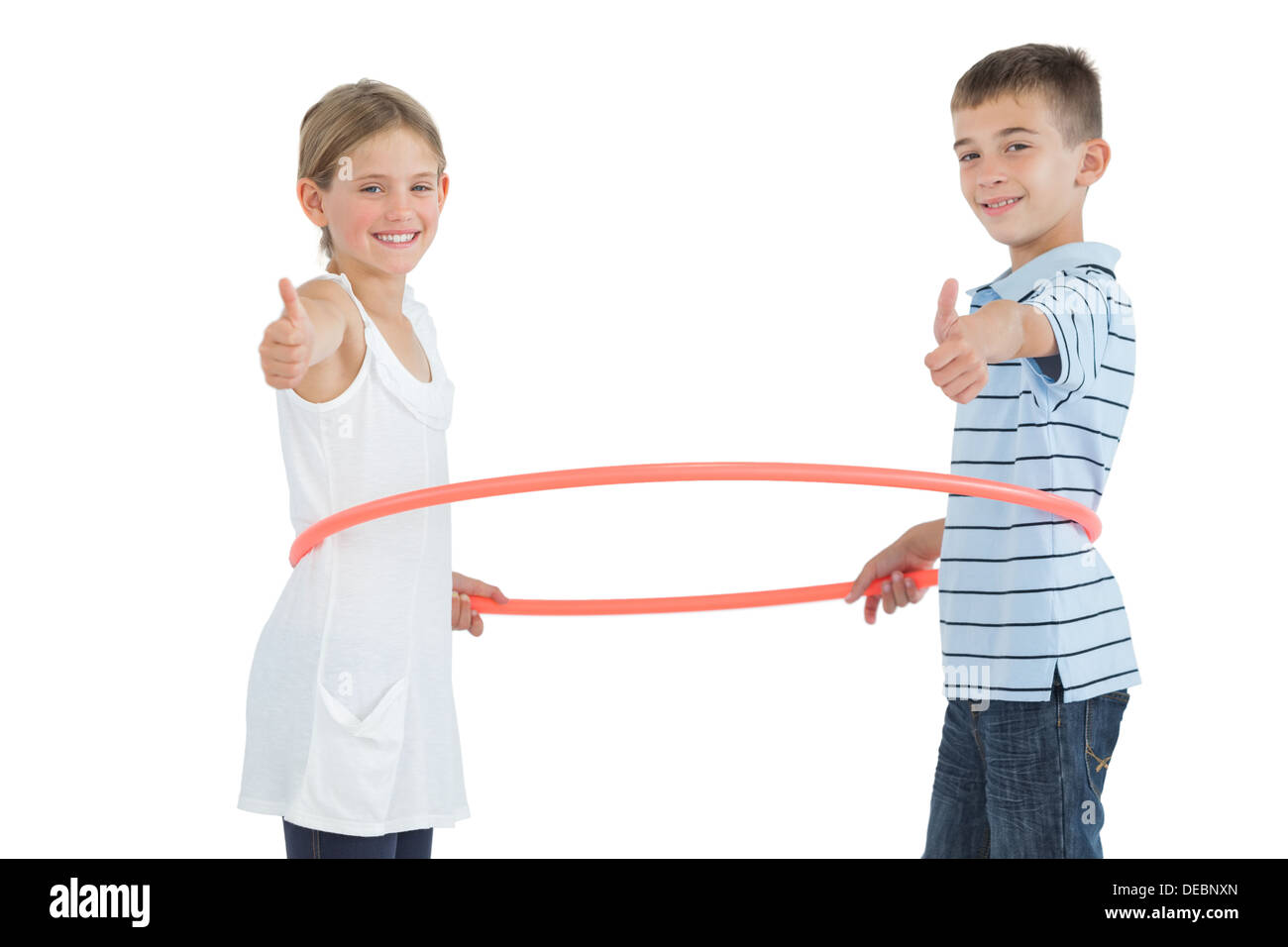 Glücklich Bruder und Schwester spielen mit Hula-Hoop Daumen aufgeben Stockfoto