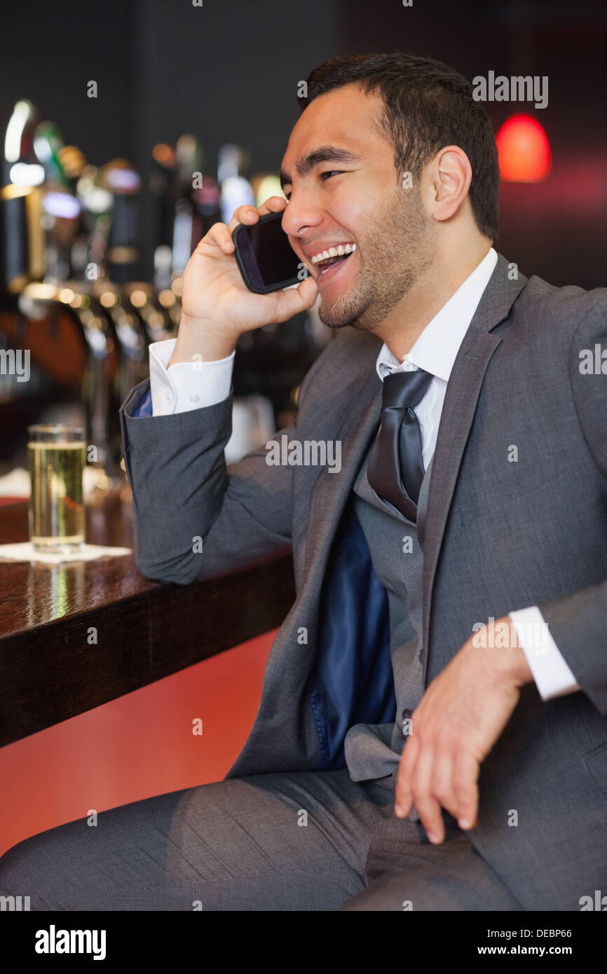 Fröhliche Geschäftsmann auf dem Handy einen Drink Stockfoto