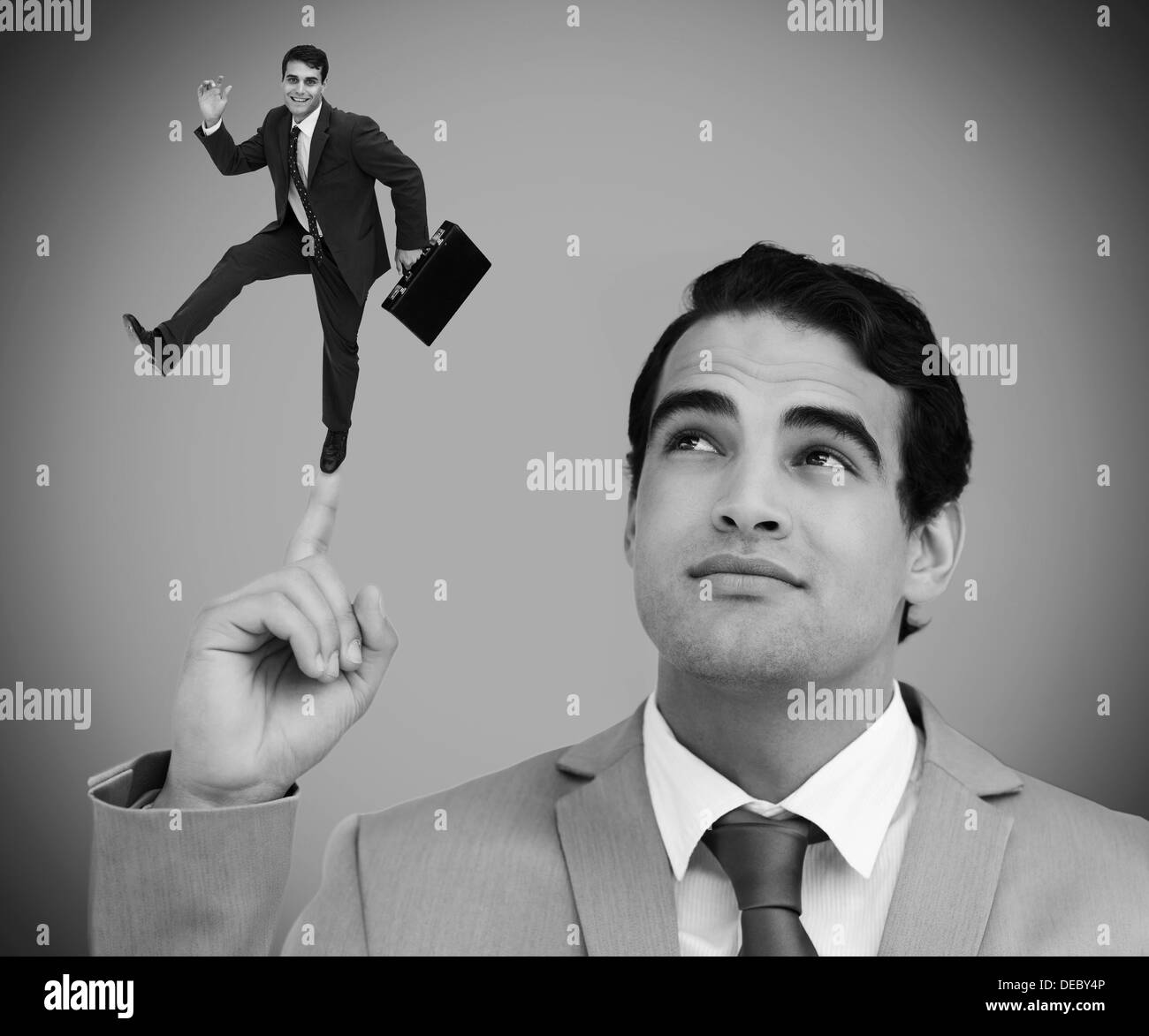 Nachdenklich Geschäftsmann zeigt geschrumpft Kollege an seinem Finger tanzen Stockfoto