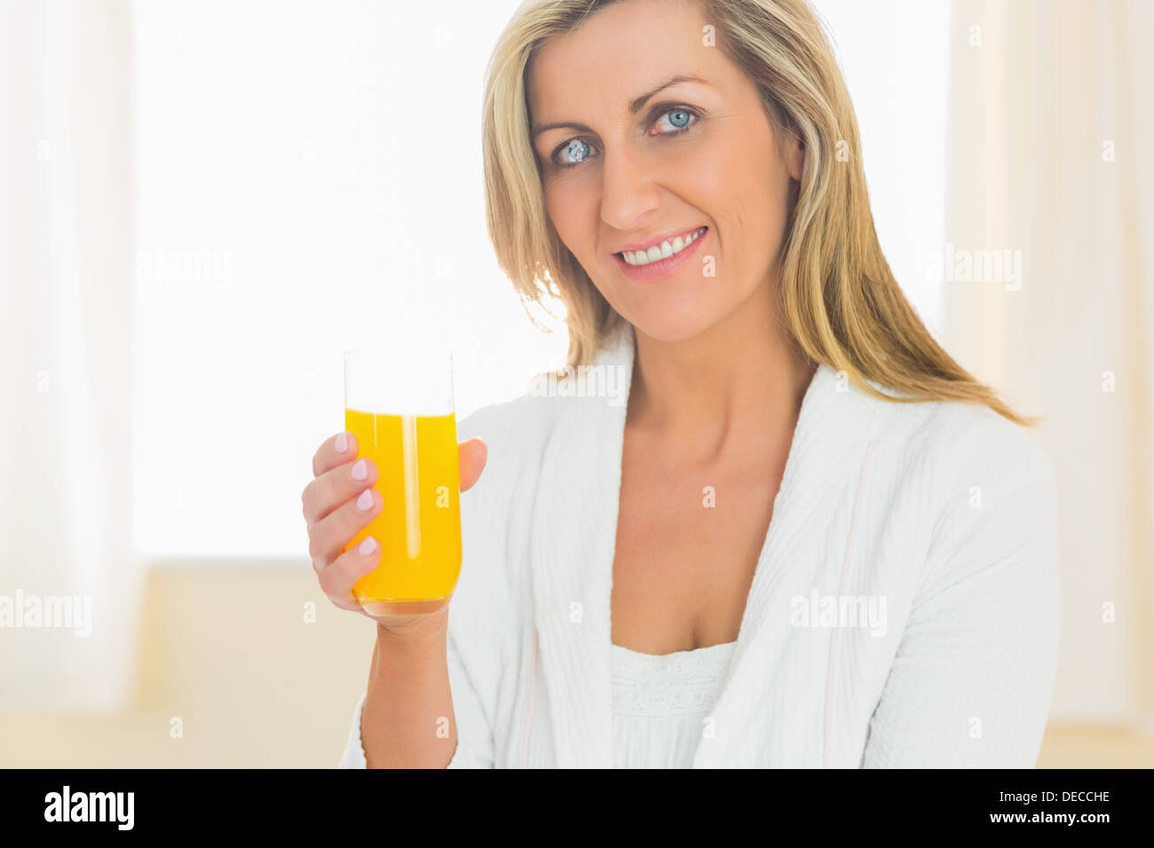 Inhalt Frau Blick in die Kamera ein Glas Orangensaft Stockfoto