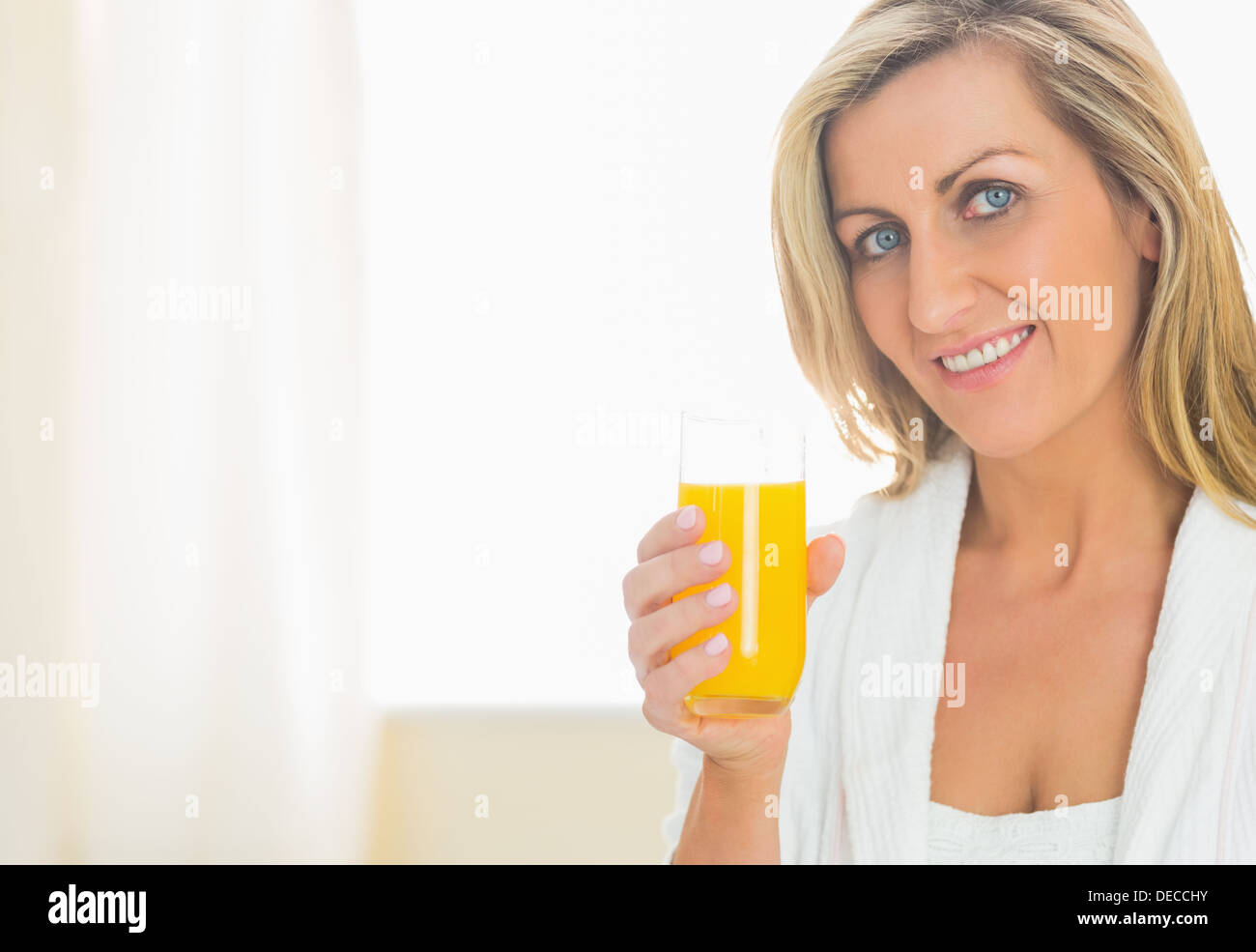 Zufrieden Frau auf der Suche nach einem Glas Orangensaft Stockfoto