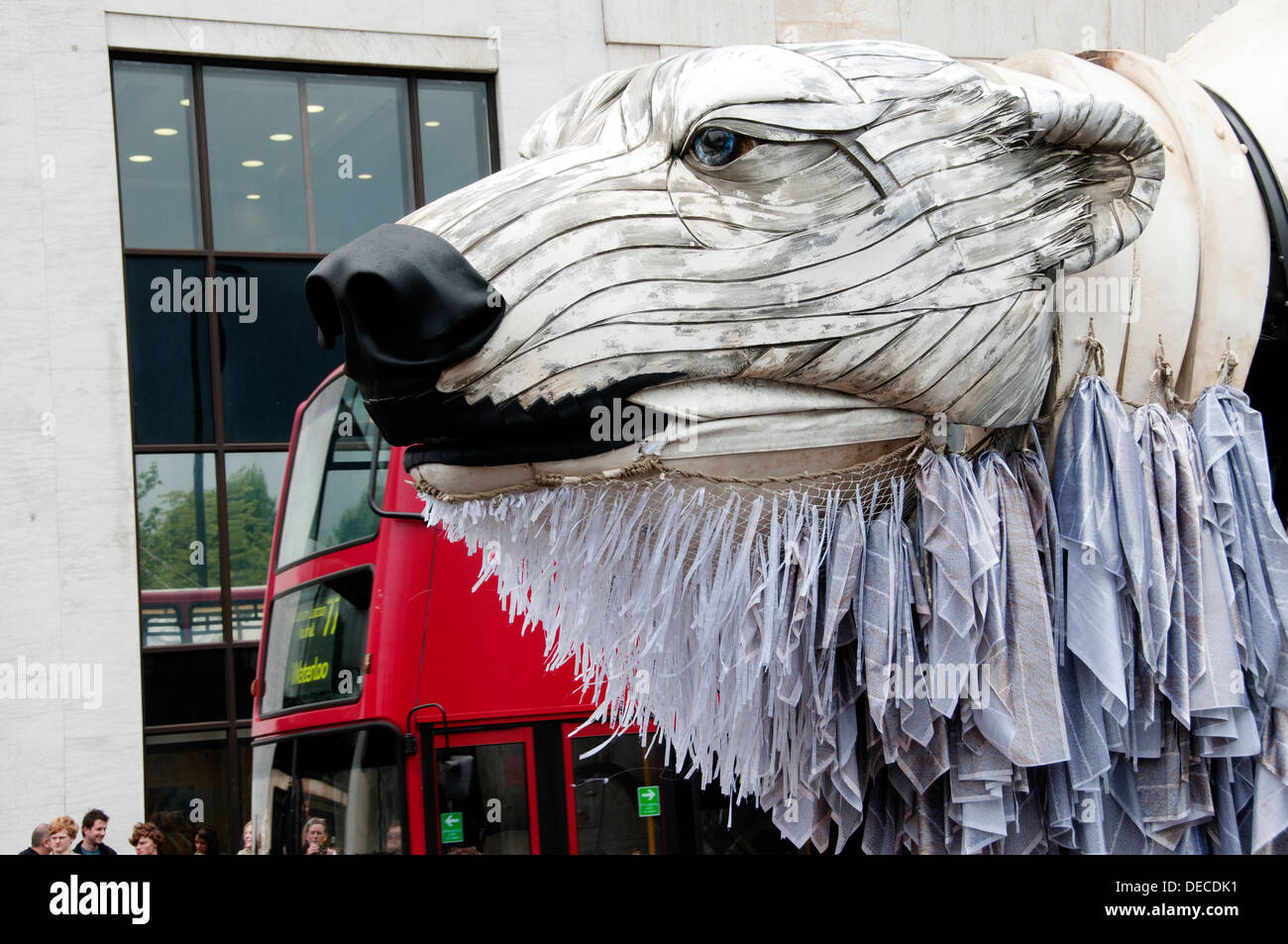 Aurora, der Eisbär-Puppe im Auftrag von Greenpeace eine Arktis-inspirierten Streetparade neben einem Doppeldecker-Bus zu führen Stockfoto