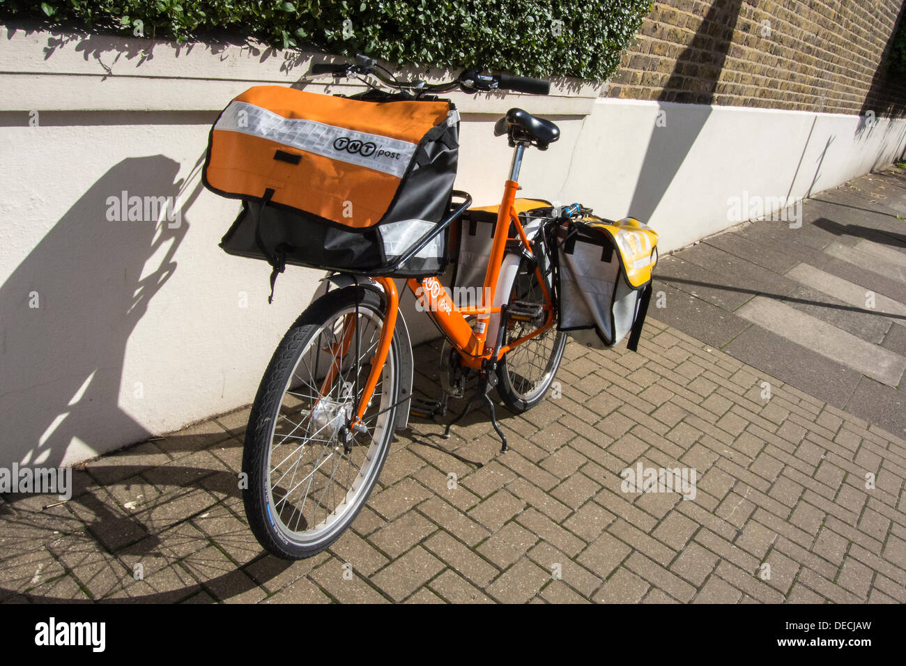 London, UK. 16. September 2013. Die Royal Mail-Flotation droht ebenso wie TNT Studien eine eigene Tür zu Tür service im Süden von London. Dies hat dazu geführt, das Erscheinungsbild der Briefträger mit markanten orangefarbenen Fahrräder der Marke TNT. Diese sind geworden ein Kuriosum und eine Bedrohung für die traditionelle Briefträger, die sind "verwirrt", dass sie unbeaufsichtigt, entriegelt und offen für Diebstahl auf Wohnstraßen, während immer noch anscheinend voll gelassen werden der Post. Bildnachweis: Guy Bell/Alamy Live-Nachrichten Stockfoto