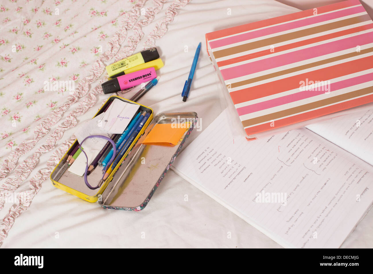 Hausaufgaben auf des Mädchens Bett Stockfoto