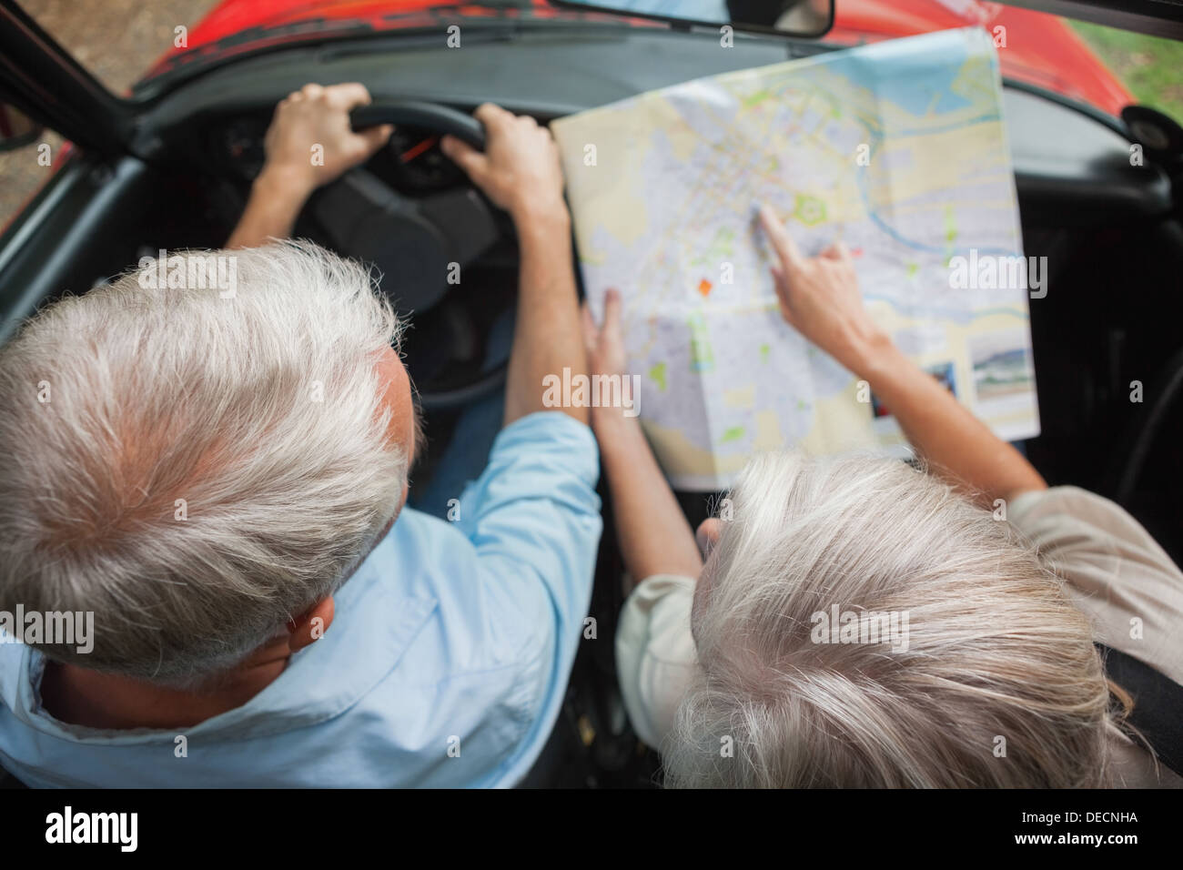 Draufsicht auf älteres Paar im Urlaub lesen Karte Stockfoto