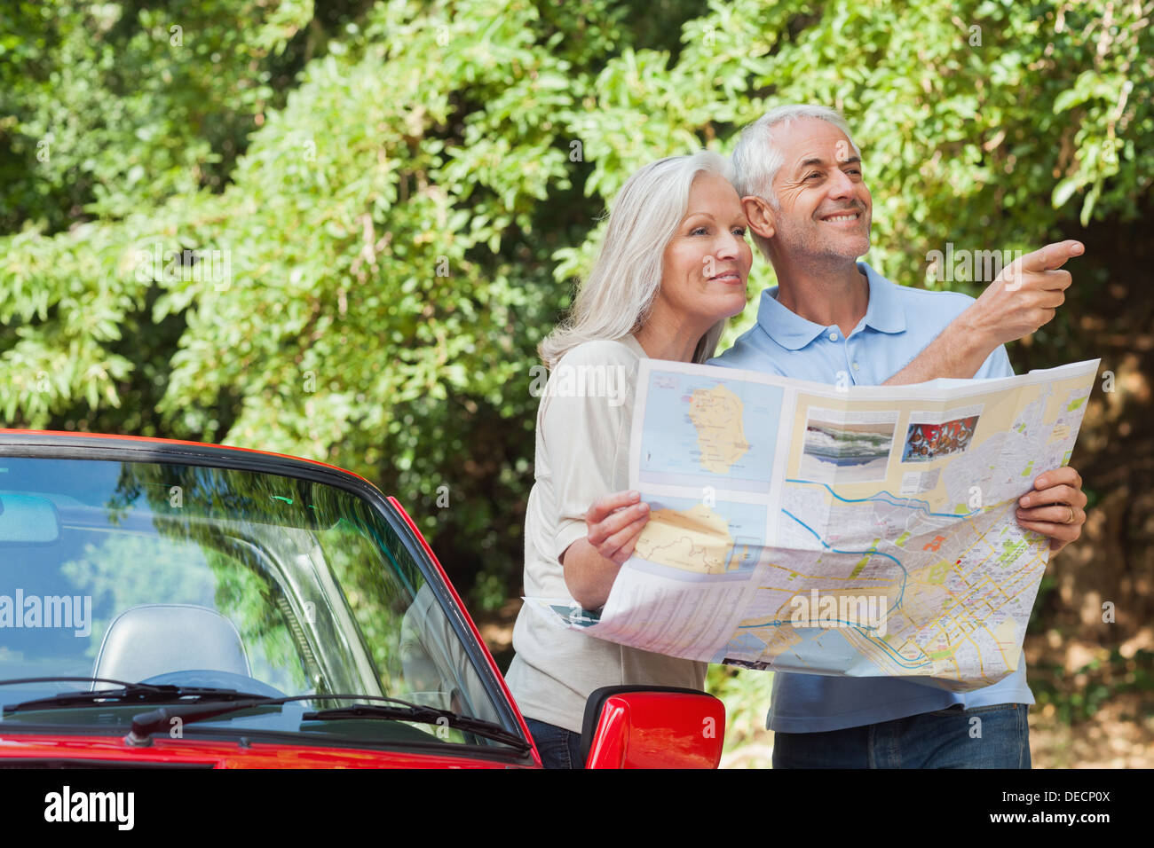 Älteres Paar fröhlich lesen Karte Suche nach Richtung Stockfoto