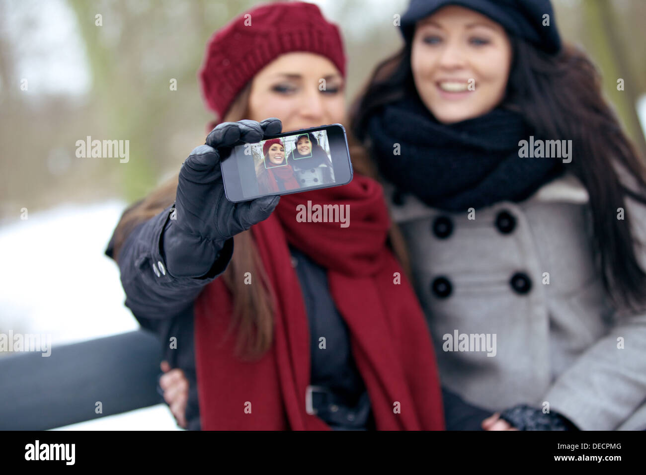 Fröhliche Frauen genießen den Winter im Freien, indem Sie Bilder von sich selbst Stockfoto
