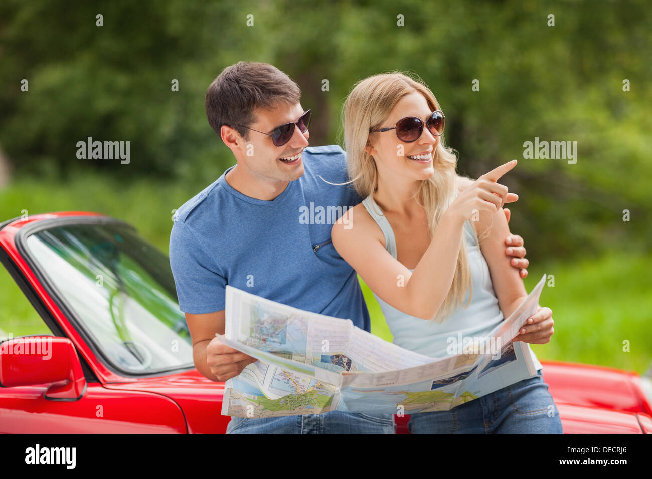 Fröhliches junges Paar Lesung Karte Stockfoto
