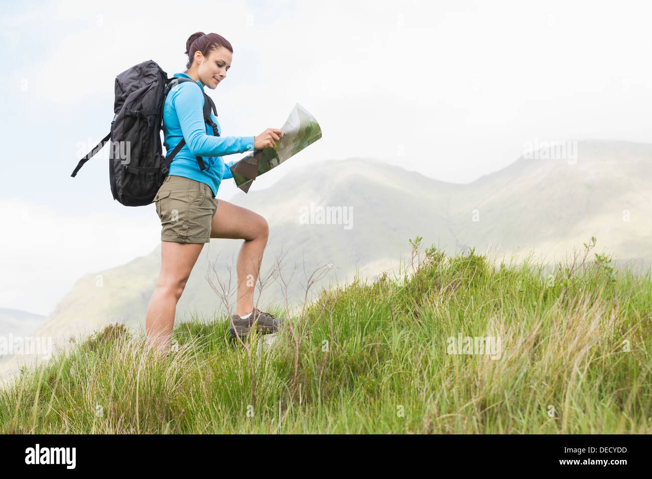 Attraktive Wanderer mit Rucksack zu Fuß bergauf Kartenlesen Stockfoto