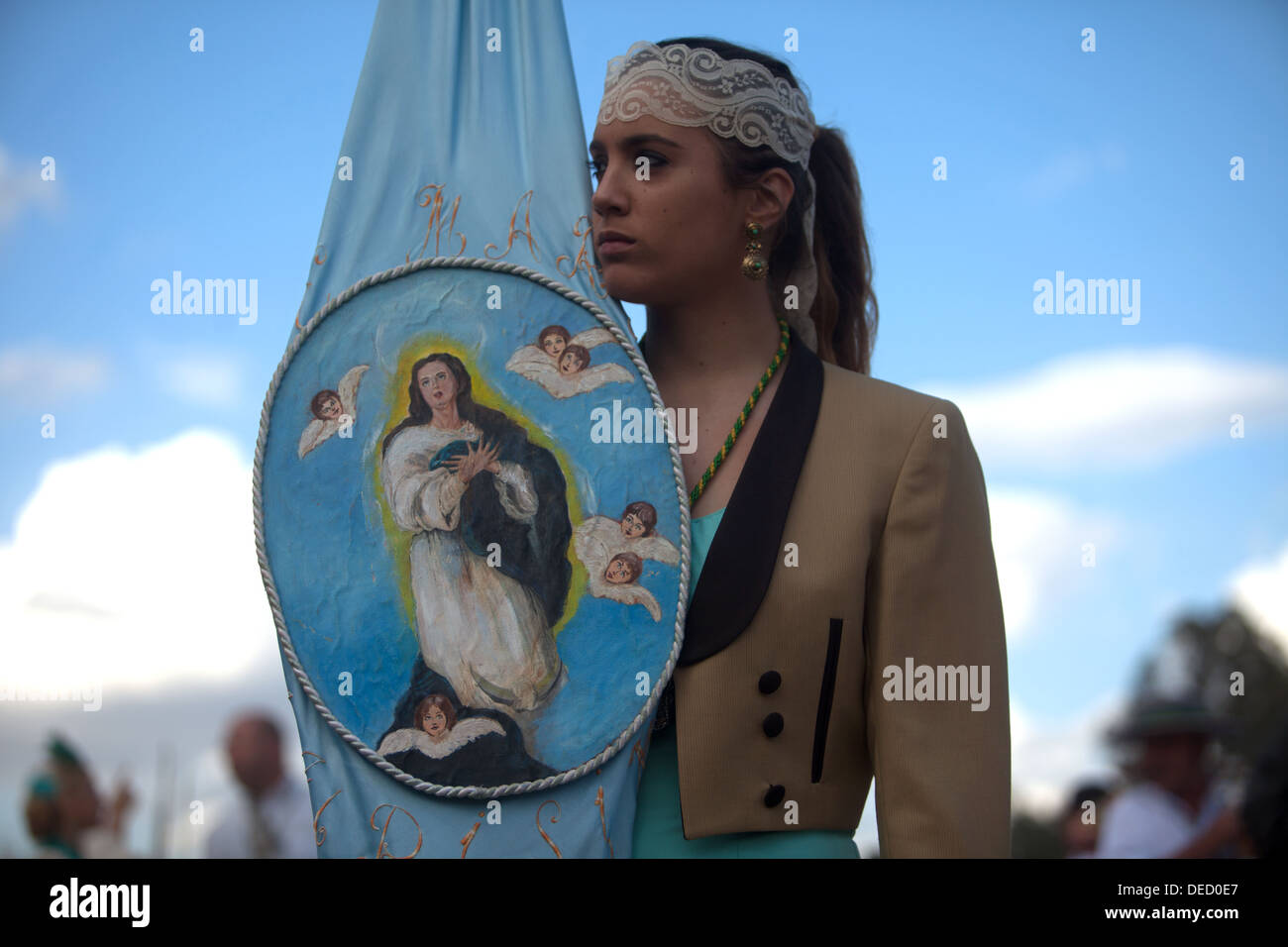 Ein weiblicher Pilger hält einen Banner der Jungfrau Maria während der Wallfahrt zum Heiligtum der Jungfrau Rocio, Spanien Stockfoto