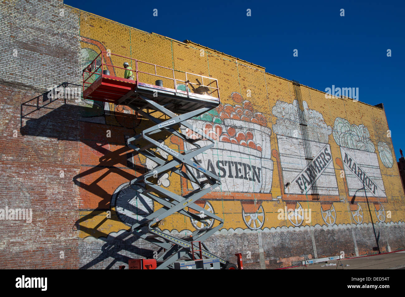 Detroit, Michigan - ein Arbeitnehmer Reparaturen das Gemälde an der Wand, die an den östlichen Markt, Markt wichtigen Bauern der Stadt. Stockfoto