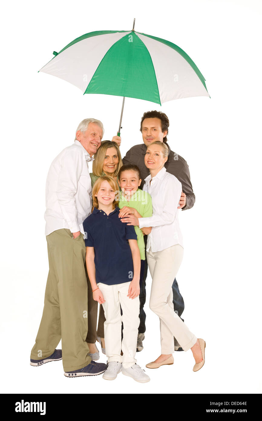 drei Generationen Familie stehen isoliert auf weißem Hintergrund mit Regenschirm Stockfoto