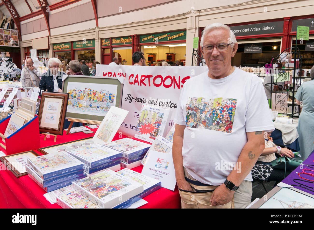 Peter Leech, Künstler mit dem Verkauf von Stall cartoon Bilder und Puzzles in Newcastle Grainger Markt, Nord-Ost-England, UK Stockfoto