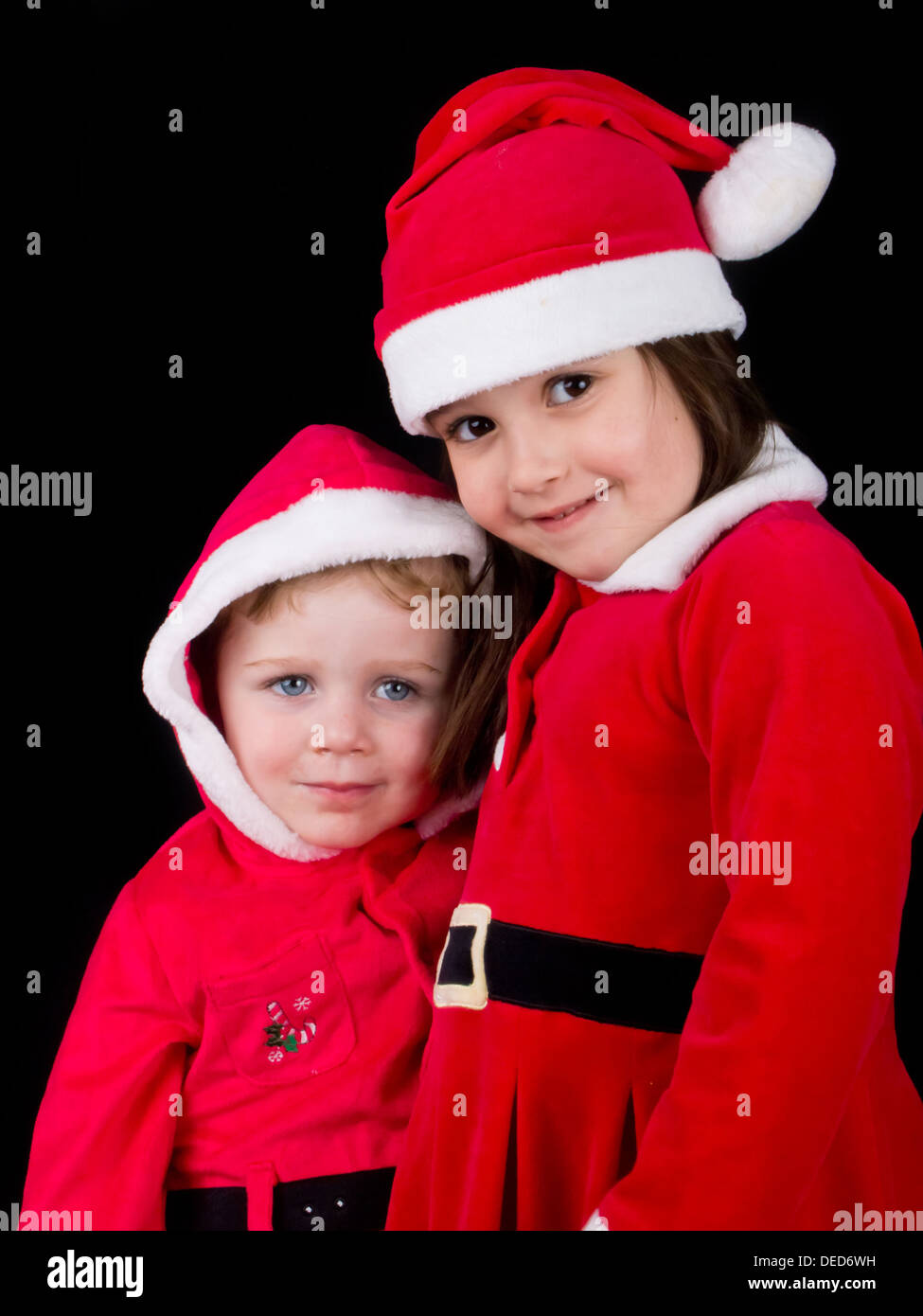 Ein kleiner Junge und ein Mädchen gekleidet in Weihnachtsmann Kostüme für Weihnachten. Stockfoto