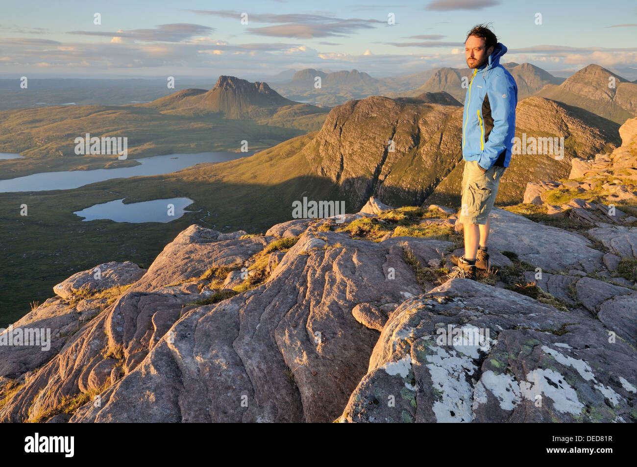 Wanderer auf dem Gipfel der Sgurr eine Fhidhleir (The Fiddler) mit Beinn ein Eoin und Stac Pollaidh im Hintergrund, Assynt Stockfoto