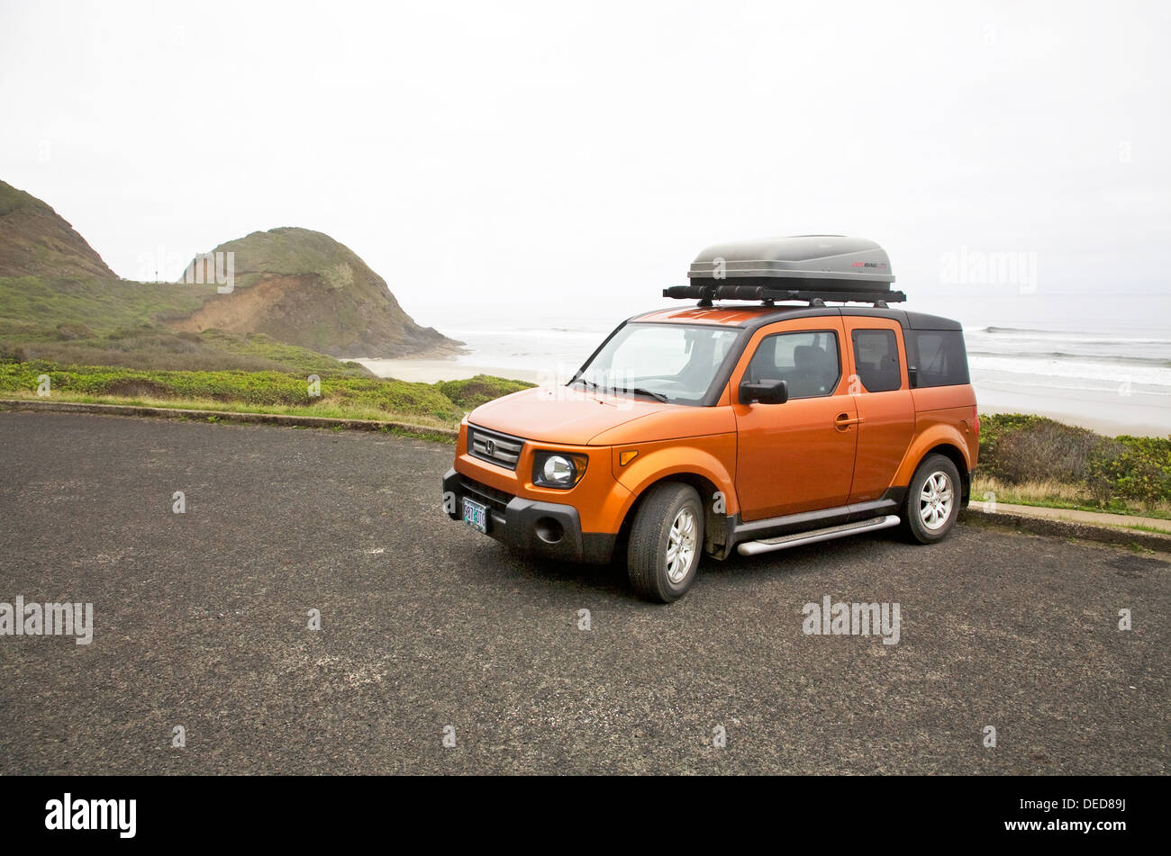 Auto mit einem Gepäckträger auf einem Oregon-Strand Stockfoto