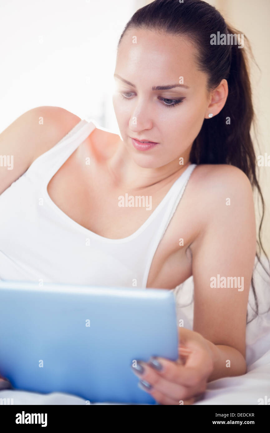 Ruhig Brünette auf Bett mit ihrem Tablet-pc Stockfoto