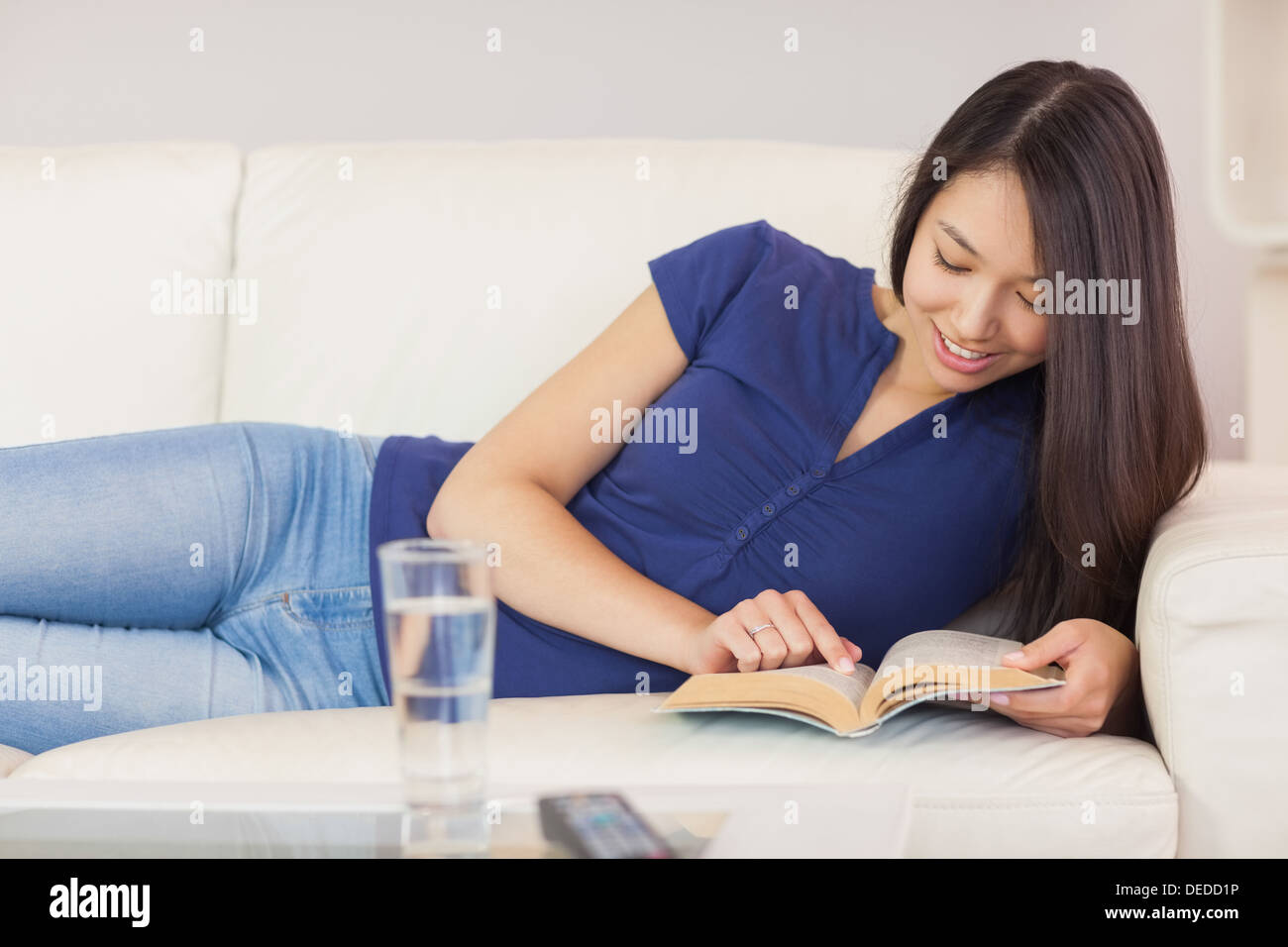 Gerne Asiatin lag auf dem Sofa einen Roman lesen Stockfoto
