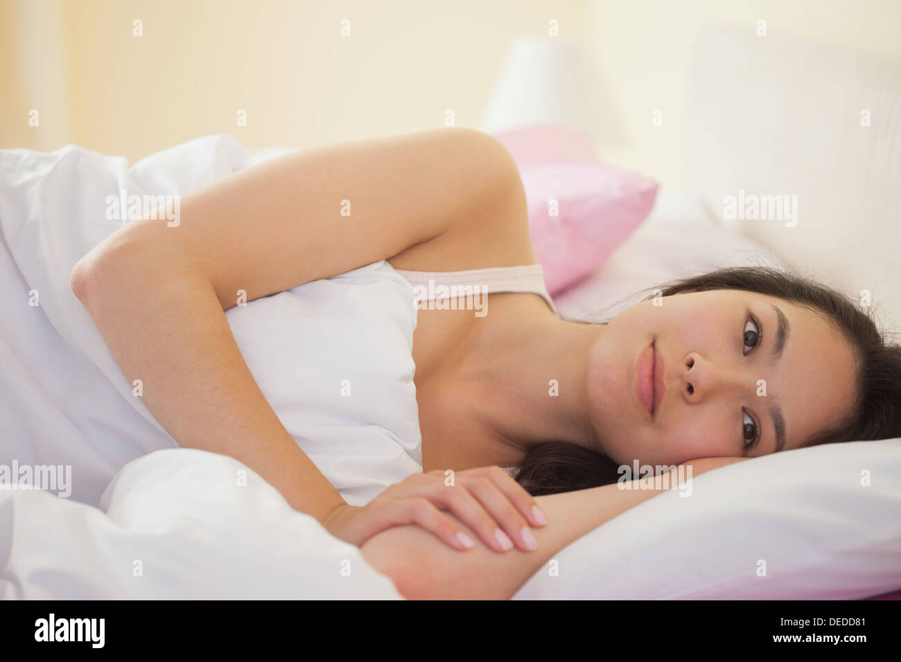 Junge asiatische Frau in ihrem Bett liegen und denken Stockfoto