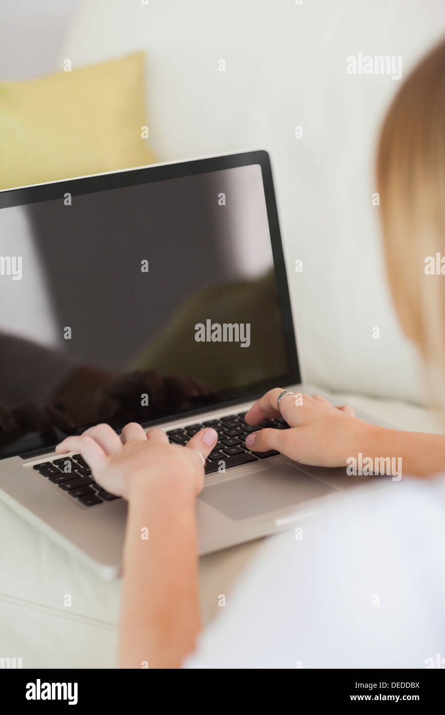 Blonde Frau auf Laptop tippen Stockfoto