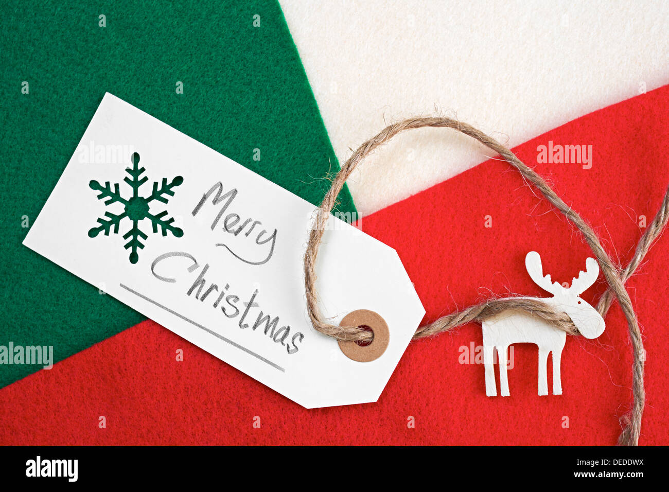 Weihnachten Geschenkanhänger auf ein rot, grün und Creme fühlte materiellen Hintergrund. Stockfoto