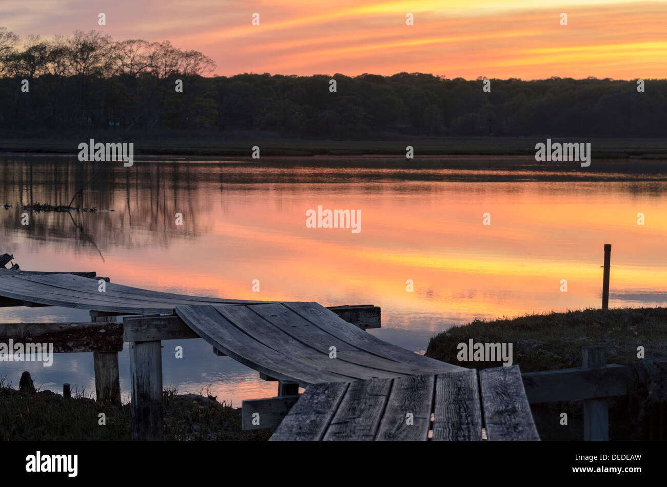 Schöne rosa und gelbe Sonnenuntergang über Connecticut Marschland mit ein altes verwittertes Holz Dock im Vordergrund. Niantic, CT Stockfoto