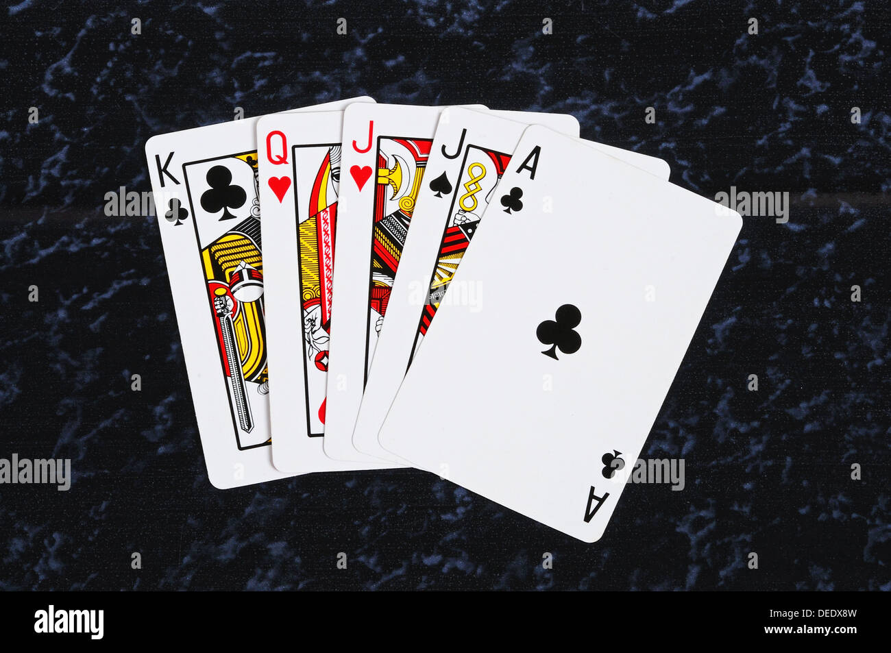 Traditionelle Spielkarten, Ass, König, Dame, Bube vor einem dunklen Hintergrund. Stockfoto