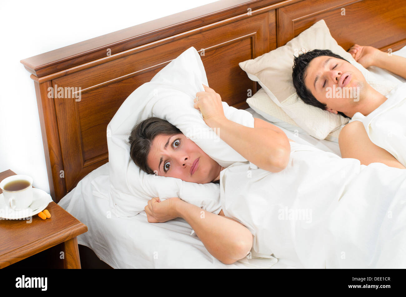 Ein Schnarcher-Mann und eine müde Frau versucht, etwas Schlaf zu bekommen Stockfoto