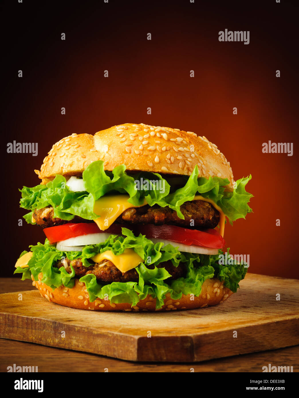 traditionelle hausgemachte leckere Hamburger oder Cheeseburger auf einer Holzplatte Stockfoto