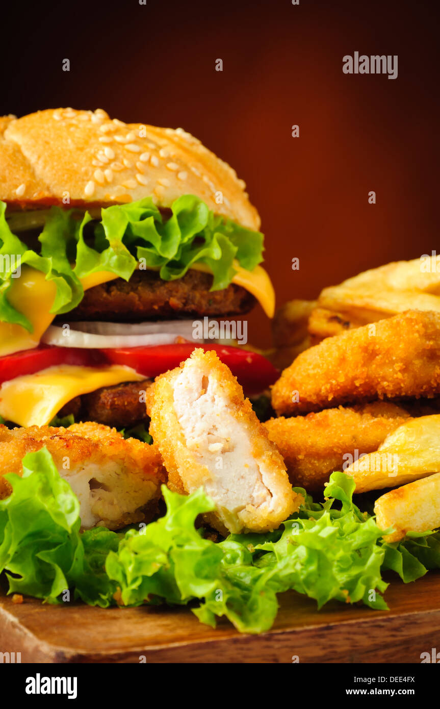 Fast-Food-Nahaufnahme mit Chicken Nuggets, Burger und Pommes frites Stockfoto