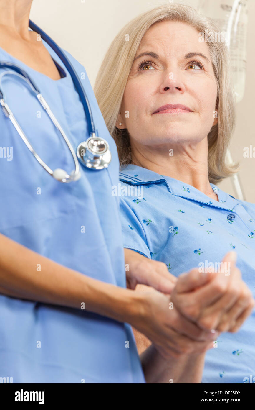 Ältere weibliche Frau Patienten in einem Krankenhausbett mit ihren Puls durch eine Krankenschwester oder Arzt getroffen Stockfoto