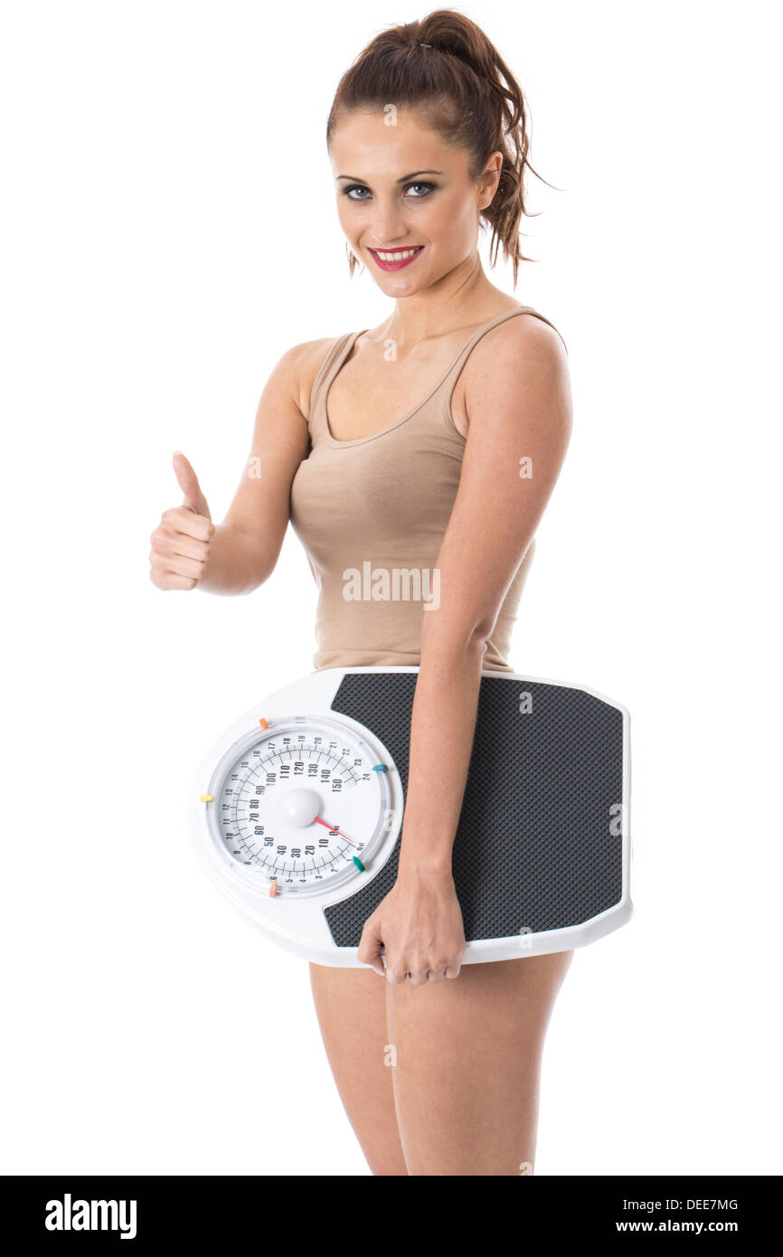 Zuversichtlich Positive junge Frau, ihr Gewicht auf die Waage, das Tragen von Vest Top, isoliert gegen den weißen Hintergrund Stockfoto