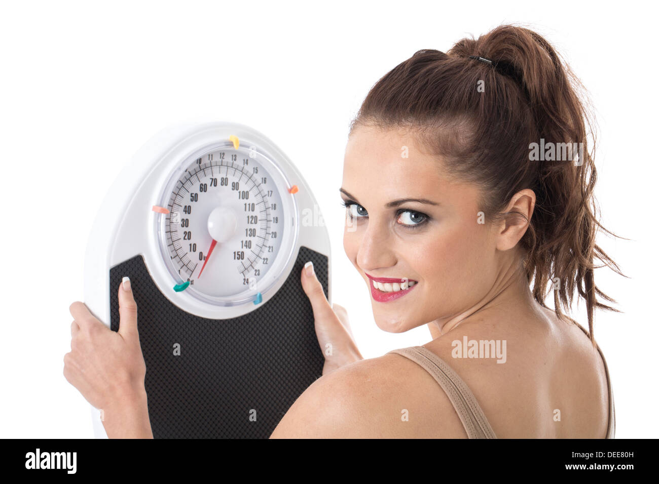 Zuversichtlich Positive junge Frau, ihr Gewicht auf die Waage, isoliert gegen den weißen Hintergrund Stockfoto