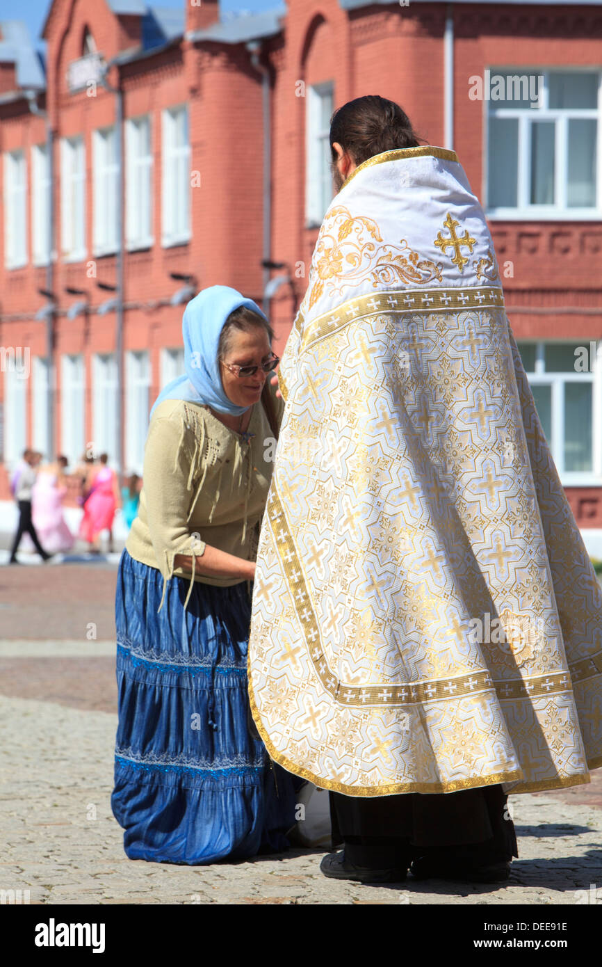 Eine ältere Dame zahlt ihren Respekt zu einem orthodoxen Priester in Kolomna, Russland Stockfoto