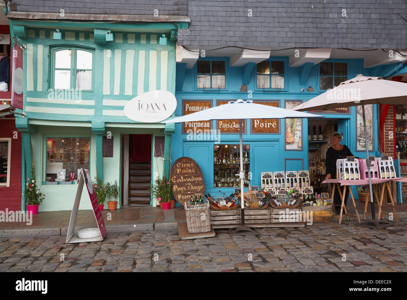 Frau Apfelwein aus Straßenstand in Honfleur, Frankreich vor den bunt bemalten Fachwerkhaus Geschäften verkaufen Stockfoto